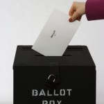 Woman inserting voting paper into ballot box